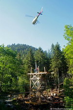 L'Ecureuil B3 de la société savoyarde Blugeon Hélicoptères a dû renoncer à installer le câble, mais a néanmoins assuré le transport d'éléments de la gare d'arrivée au sommet de la tour en bois de 15 m, plantée au bord de la Moselotte - Photo Michel Laurent