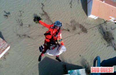 Entre Villedoux et Charron, hélitreuillage d'une dame âgée par un sauveteur-plongeur de l'escadron de Cazaux - Photo armée de l'air / EH01067)