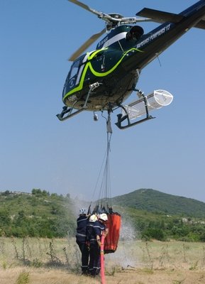 Les hommes remplissent le "seau"qui viendra remplir le bac de 3500 litres déjà installé au sommet - Photo Mathilde Boussion