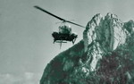 Bell 47 G2 de la base de Grenoble en approche ; il est équipé de 2 civières (Les 3 Pucelles en arrière-plan) - Photo collection F. Delafosse