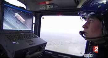 Tiphaine Morin, opérateur de bord, observe un mur d'écrans vidéo et dirige avec un joystick la caméra thermique fixée sous le ventre de l'appareil - Photo France2