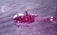 Roger Colin (Mécanicien d'équipage), en combinaison de plongée sur le bord de la machine, finit de treuiller une victime depuis l'Alouette II F-ZBAK de la Protection civile - Photo DR