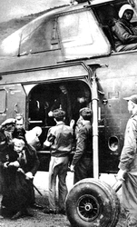 Arrivée à Briançon d'une ceillaquine (Mme Nicolas) par hélicoptère Sikorsky H-34 piloté par le lieutenant Serge Cessou (commandant de bord) - Au sol à l'extrême droite, le lieutenant René Bourcier, en juin 1957 - Photo DL