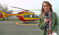 La journaliste Julie Ségala sur la Base hélicoptères Sécurité civile de Grenoble-Le Versoud - L'EC 145 Dragon 38 en arrière-plan - Photo TéléGrenoble