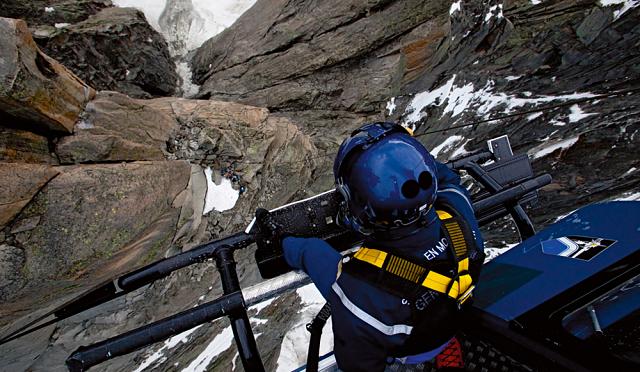 Sous le regard de Fred le mécanicien dans l'hélico, les gendarmes préparent les accidentés pour l'hélitreuillage. La météo, incertaine, risque de devenir excécrable : l'opération ne doit pas dépasser les dix minutes - Photo Philippe Petit 