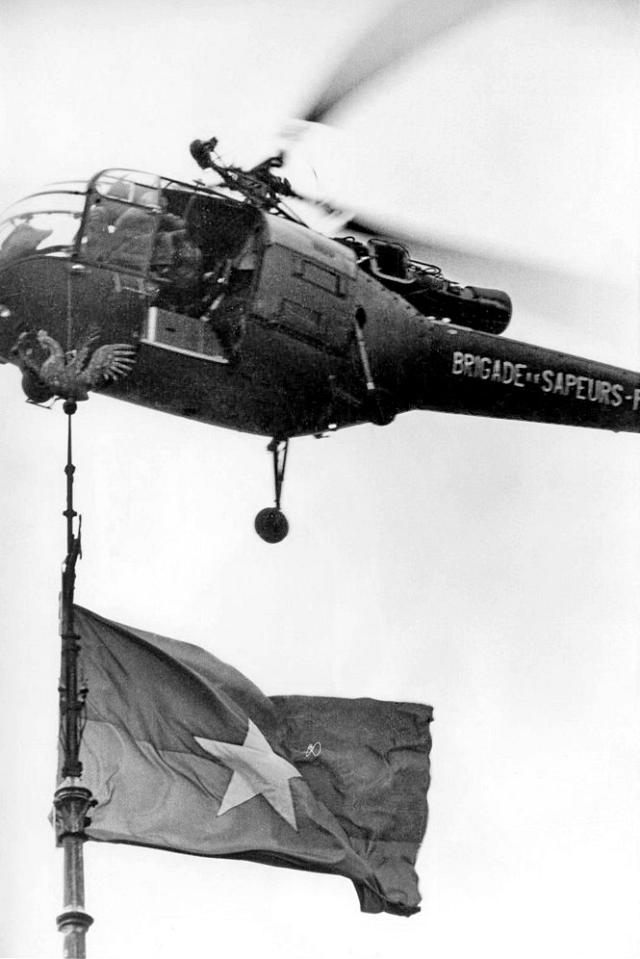 L'Alouette III F-ZBDC de la Brigade de Sapeurs-Pompiers de Paris survole de fameux drapeau accroché à la flèche du transept de Notre-Dame, le 19 janvier 1969 - Photo DR