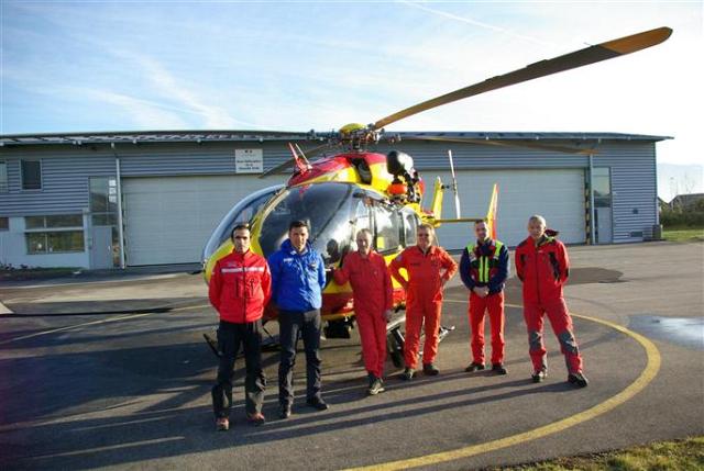 Devant l'EC 145 Dragon 74, une partie des hommes de la Sécurité civile, accompagné de deux secouristes sapeurs-pompiers de Haute-Savoie et de Savoie, mercredi après-midi sur la base de Meythet - Photo Stéphane Bouchet/DL
